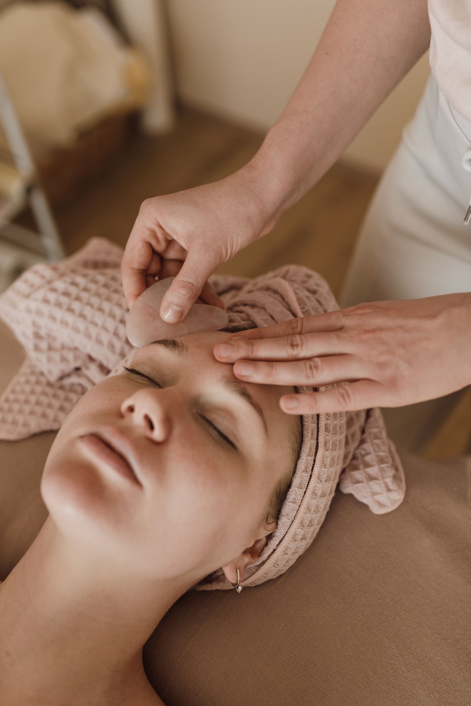 Client receiving a facial treatment in a warm, calm treatment room